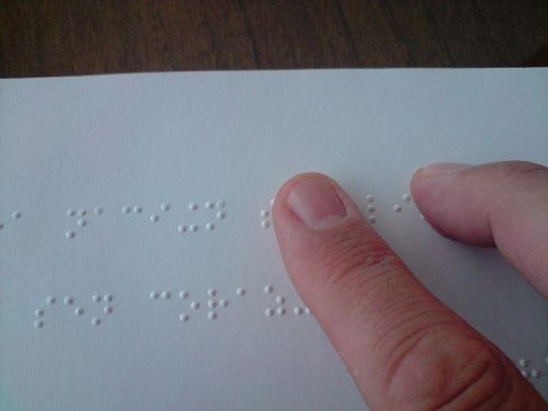 A_person_reading_a_braille_book