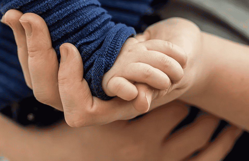 Main enfant bébé dans main adulte
