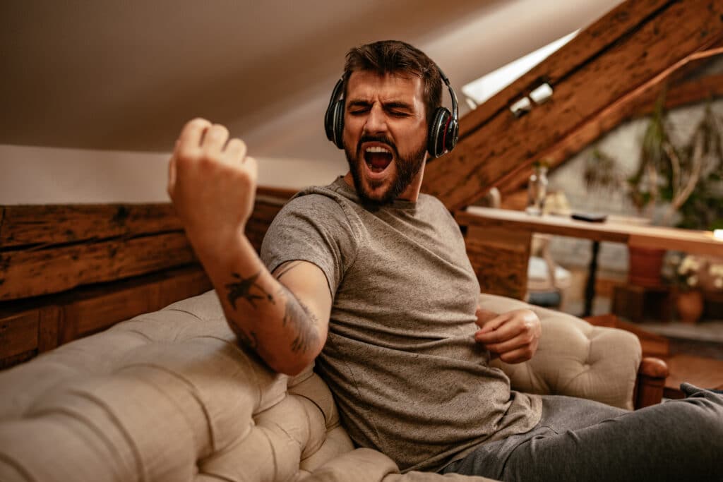 Jeune homme qui joue de l'Air Guitar chez lui