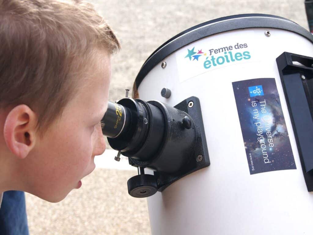 Un enfant regardant à travers un télescope à la Ferme des étoiles lors du Festival d’astronomie de Fleurance.
