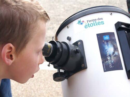 Un enfant regardant à travers un télescope à la Ferme des étoiles lors du Festival d’astronomie de Fleurance.