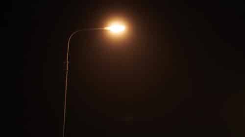 Un lampadaire allumé durant la nuit.