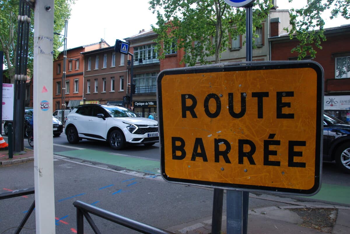 Un panneau "route barrée" sur l'avenue Etienne-Billières en travaux à Toulouse. Derrière, une queue de voiture à l'heure de pointe