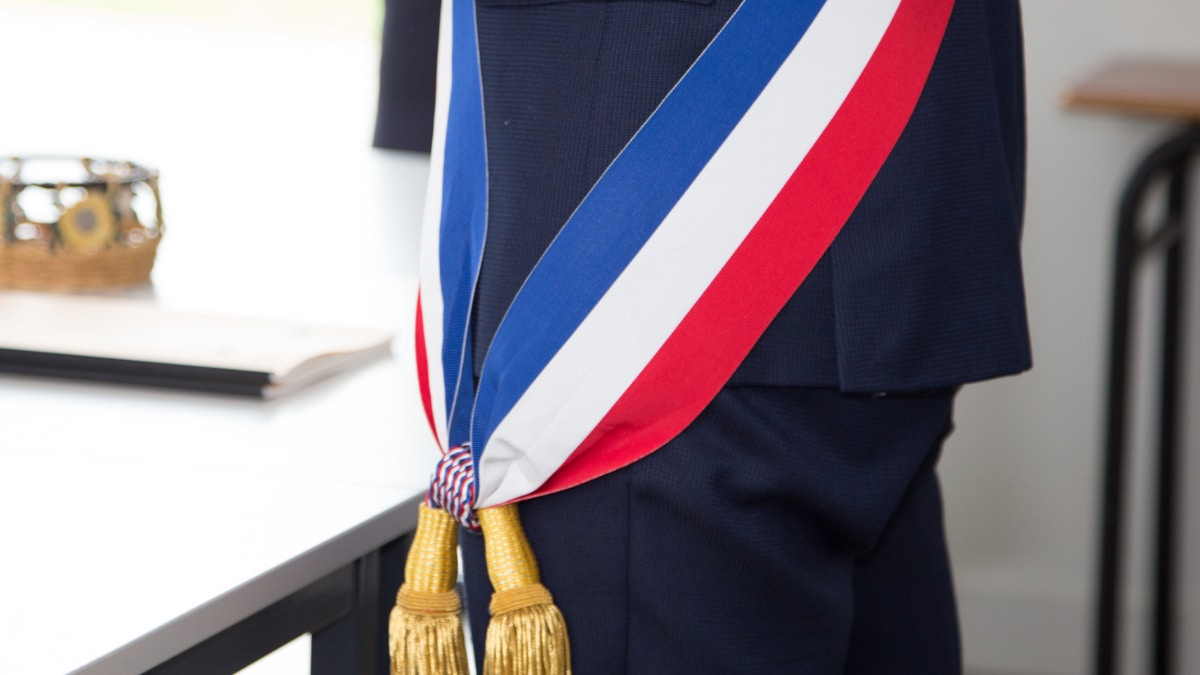 Un maire avec son écharpe tricolore.