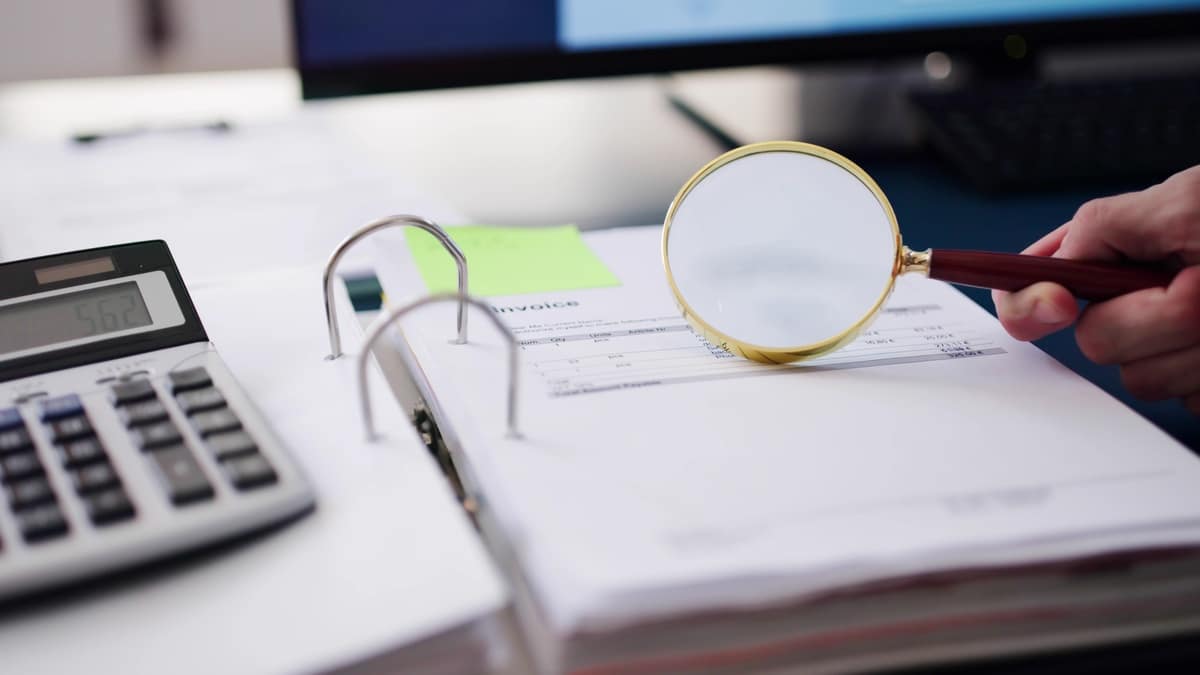 Une loupe sur un livre de comptes.