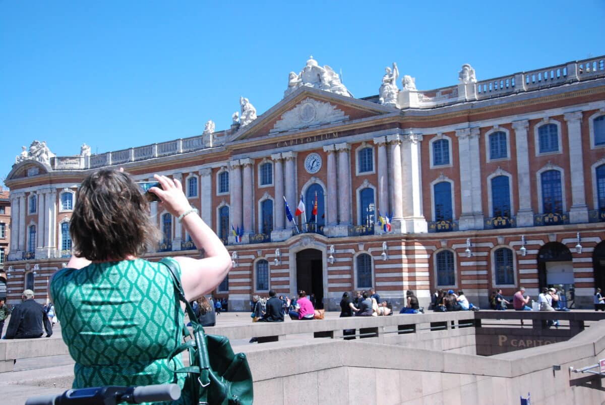 Une touriste photographie la place du Capitole, à Toulouse.