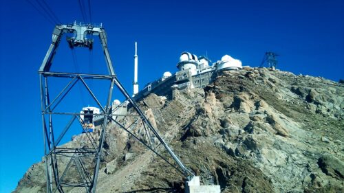 Vue de l’observatoire du Pic du Midi perché à 2 877 mètres, avec ses coupoles scientifiques et une vue panoramique sur les sommets enneigés des Pyrénées.